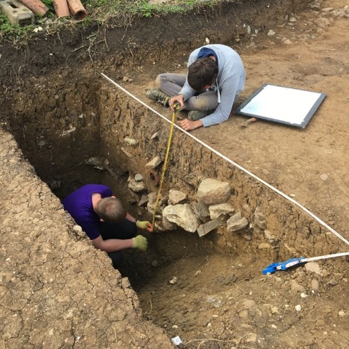 A photograph showing archaeologists excavating the enclosure ditch.