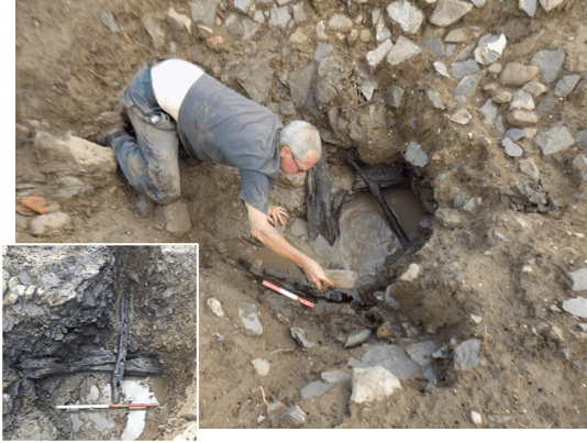 A photograph of an archaeologist excavating waterlogged medieval building timbers from a well.
