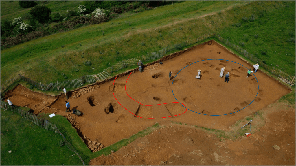 The excavation in the south-west corner of the hillfort with the Early Bronze Age C-shaped enclosure (red) and later Iron Age roundhouse (blue) highlighted. Image: ULAS